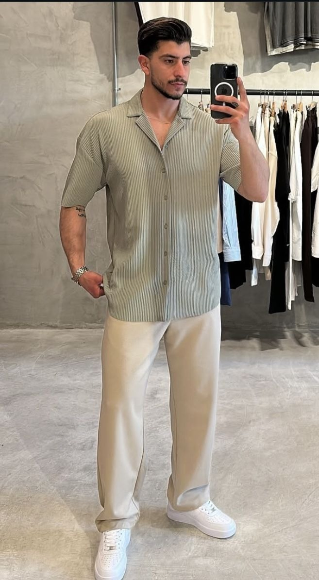 Produção masculina com camisa verde-clara e calça bege